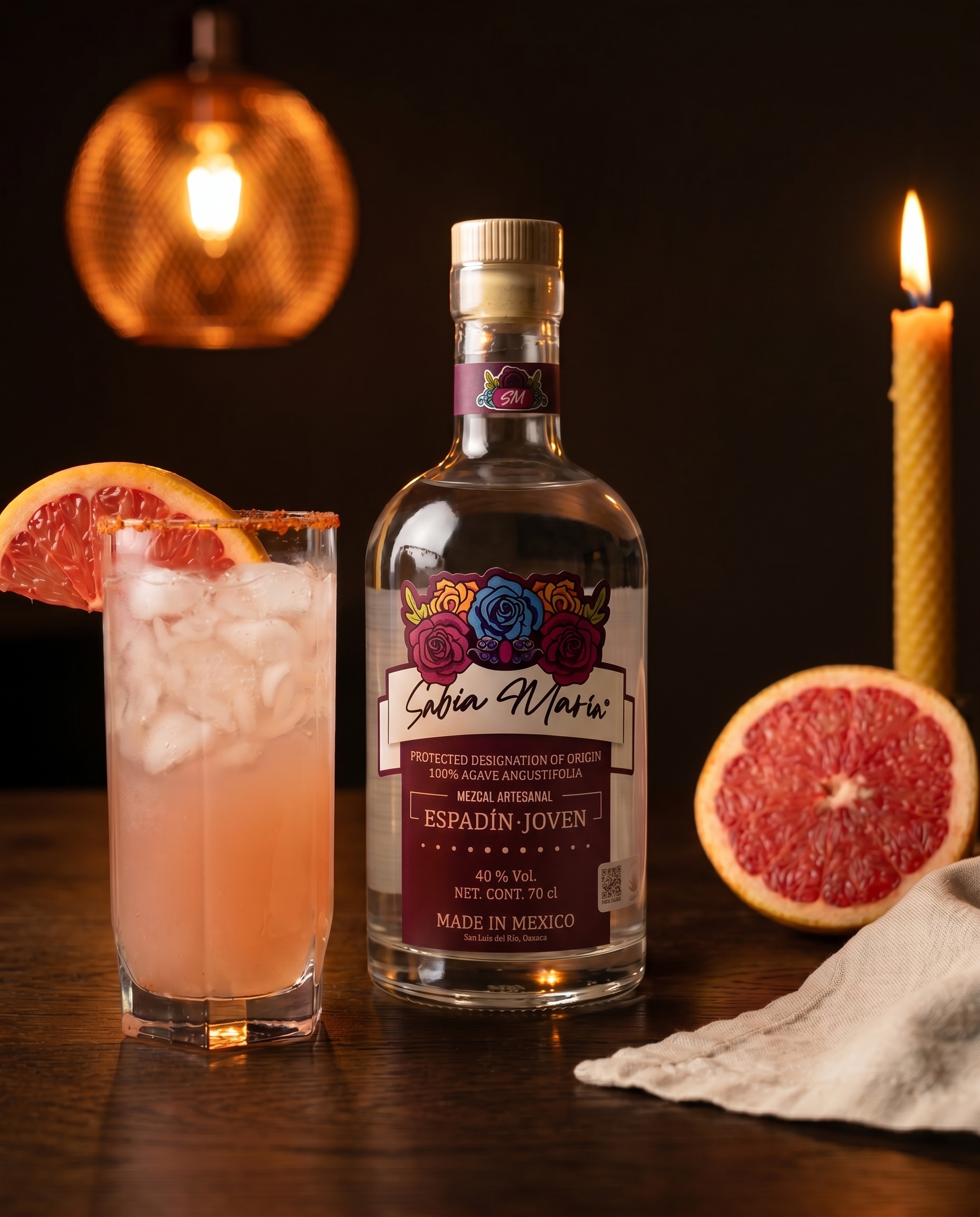 Frosted clay cantarito of Somos Paloma on raw oak, pink grapefruit wheel on the rim, Sabia Maria bottle softly out of focus.
